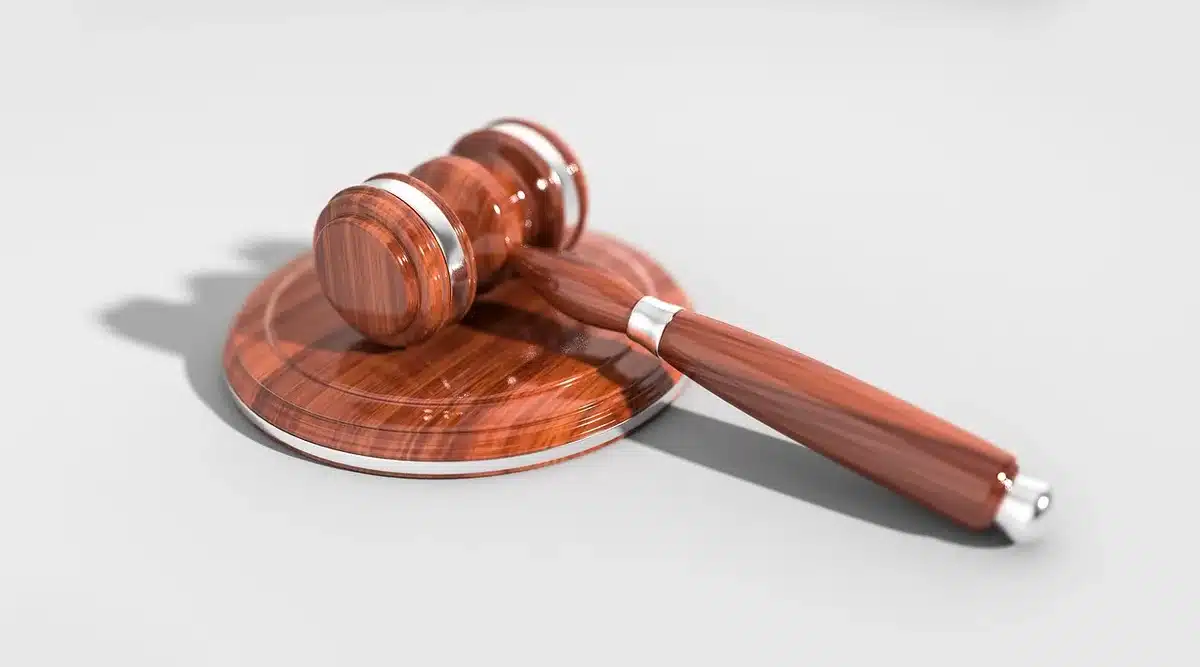 Auctioneer's gavel above a vintage whisky bottle during an auction