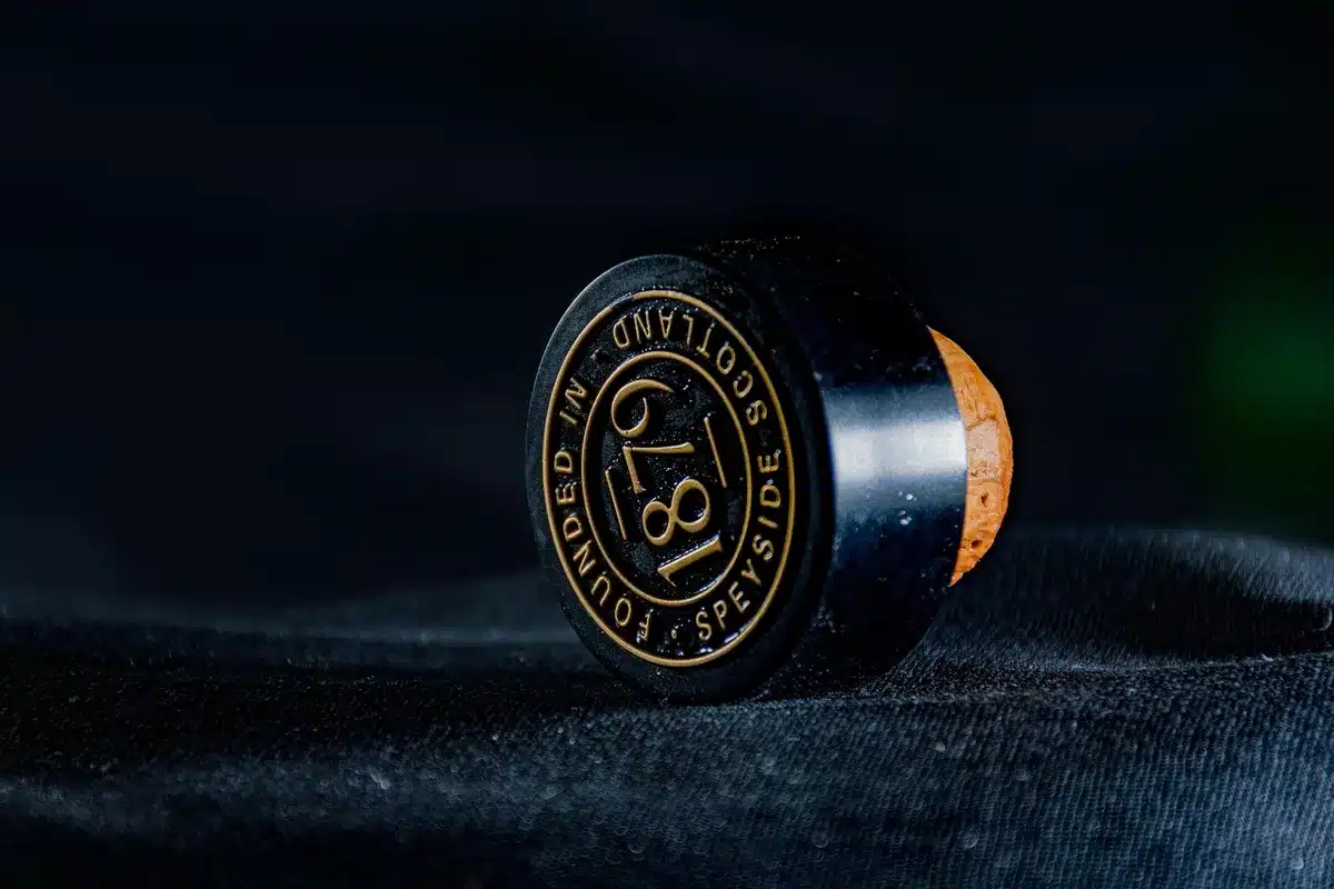 Close-up of a whisky bottle's cork and fill level being inspected
