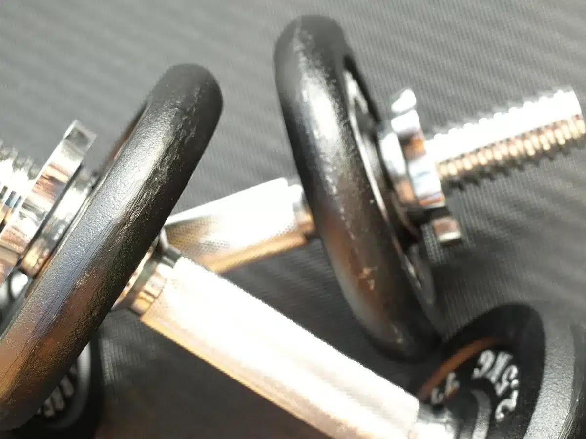Dumbbells and a mat at home representing a shifting routine toward strength training