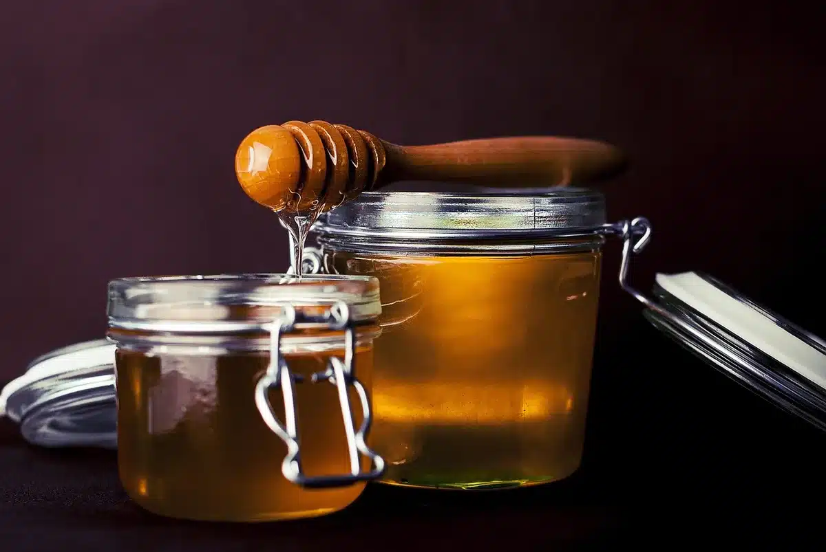 Glass jars of homemade applesauce neatly labeled on a pantry shelf