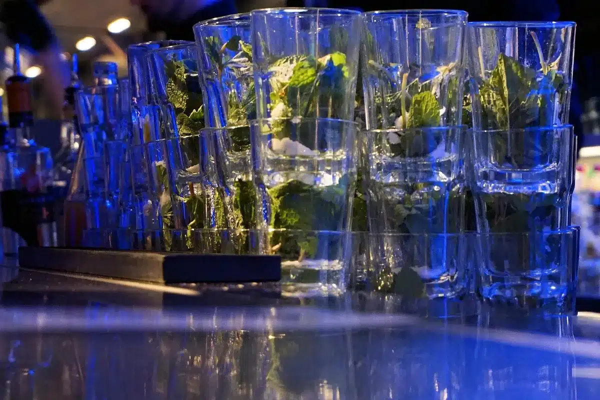 Bartender muddling mint for a mojito behind the bar