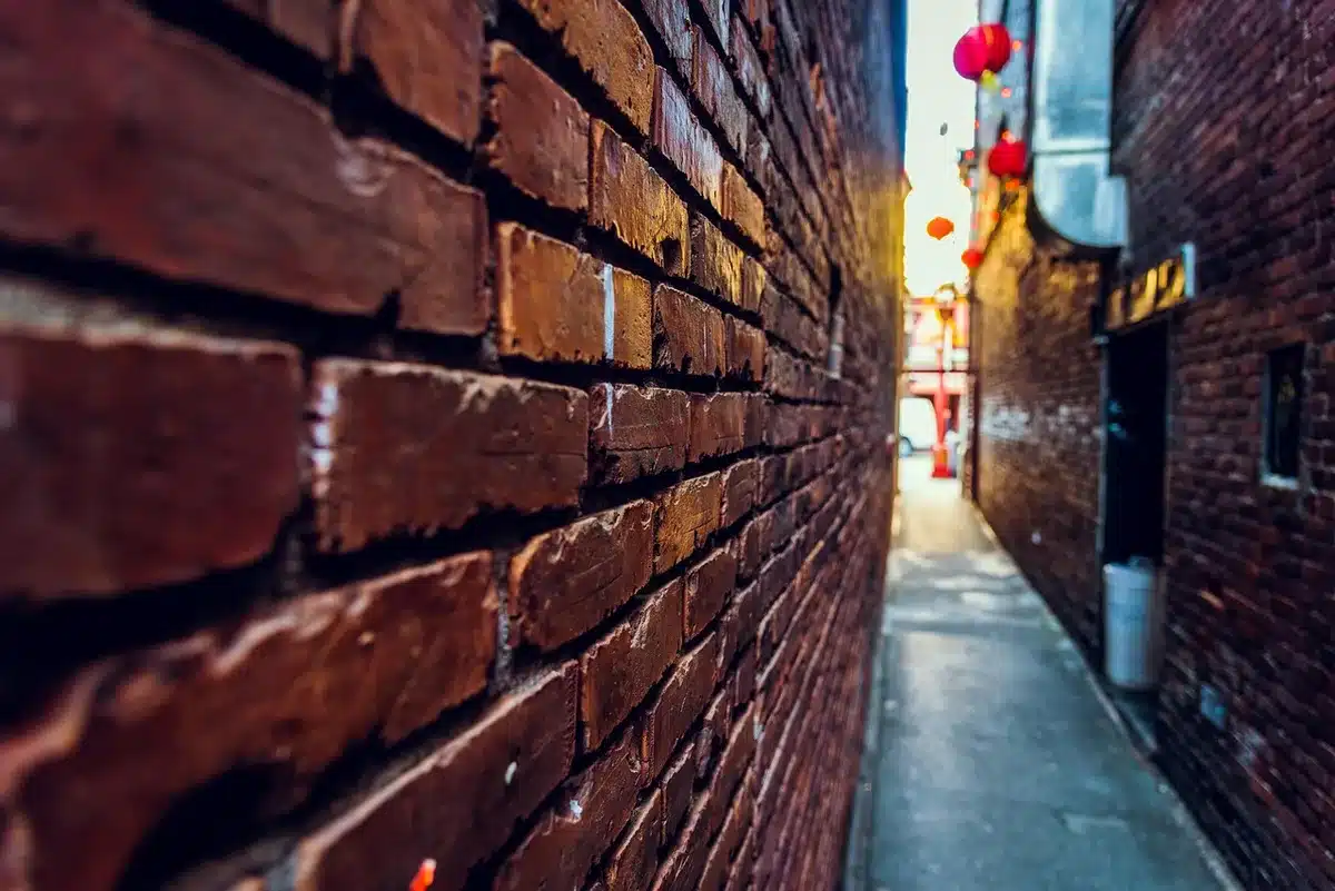 Compact Chinatown street with bright signs and open restaurant doors