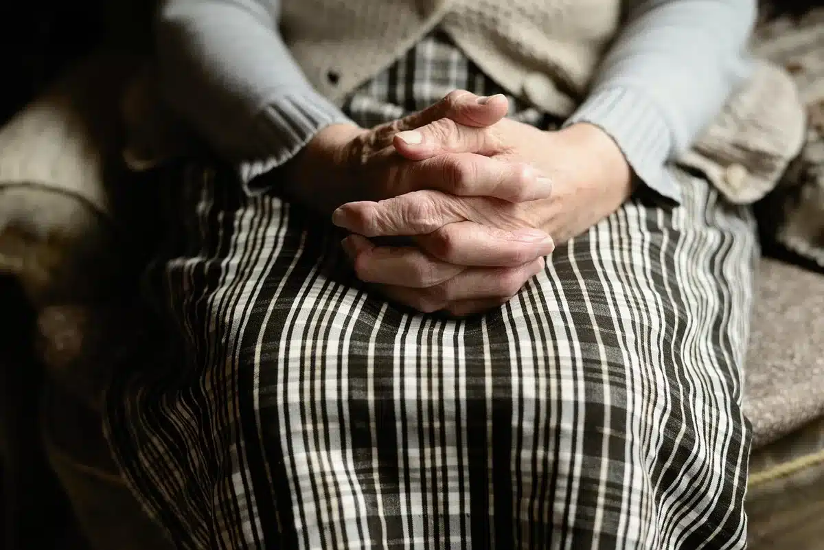 Hands performing stretch-and-fold on dough in a bowl