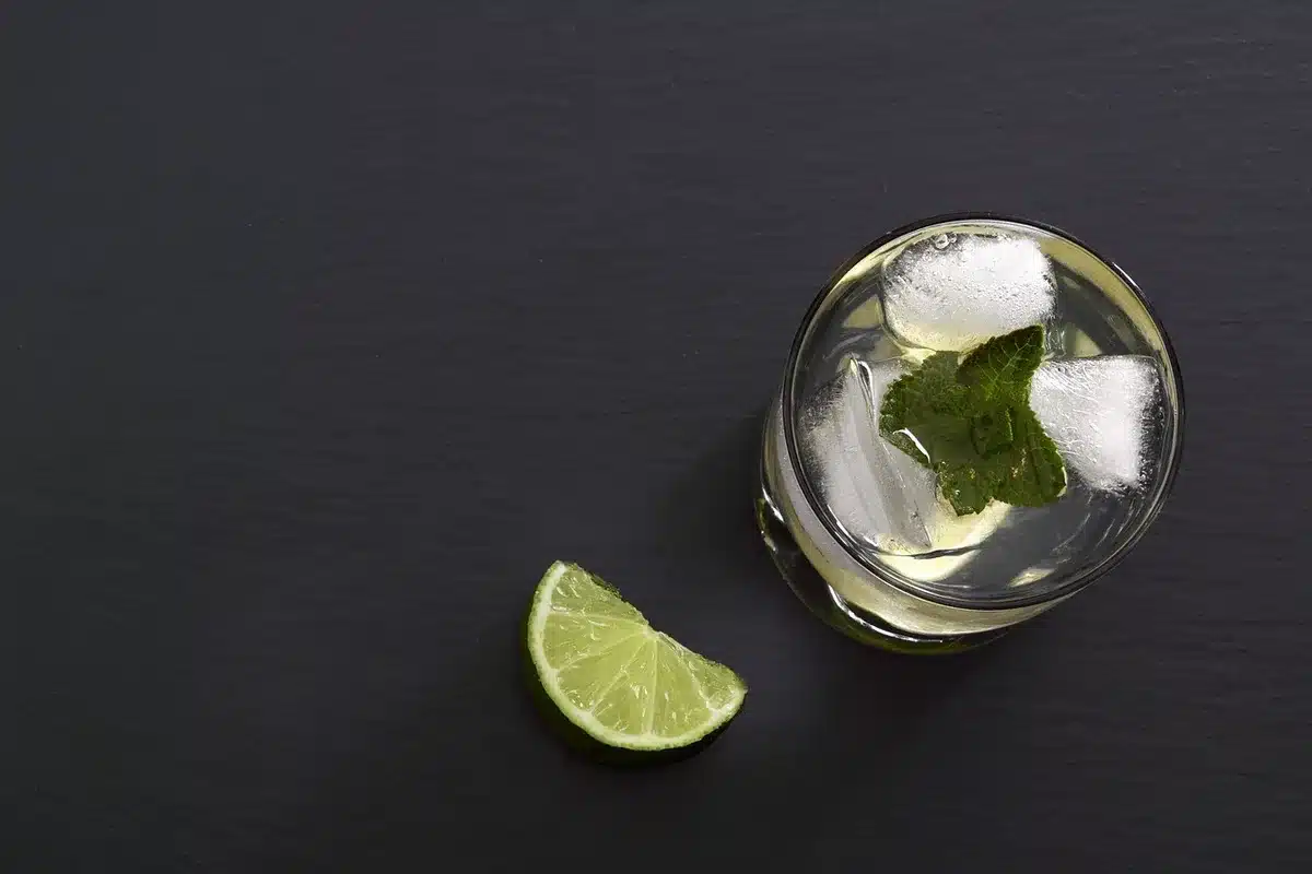 Chilled blanco tequila in a glass with lime and salt rim on an outdoor table