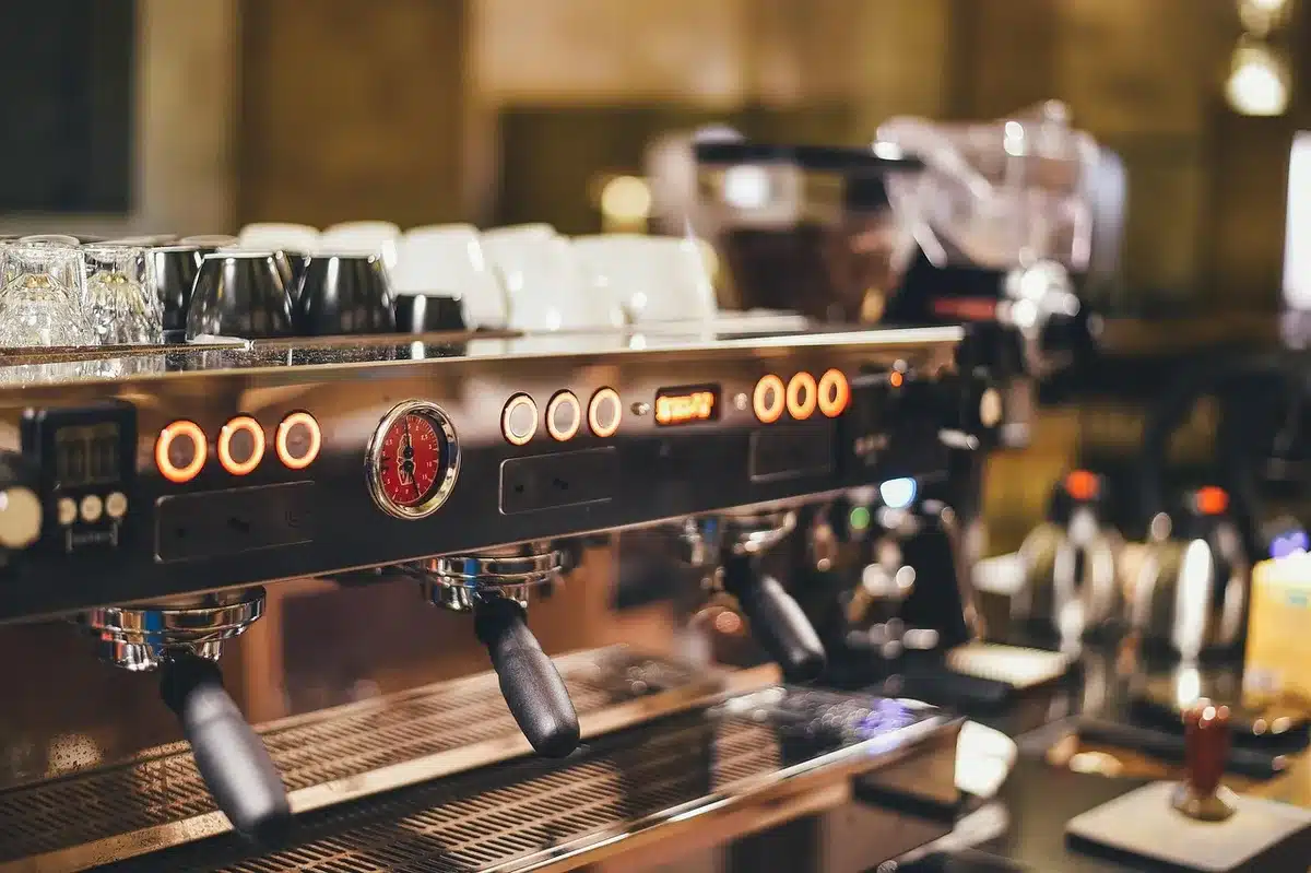 Compact espresso machine brewing a shot at home with steam rising from the portafilter