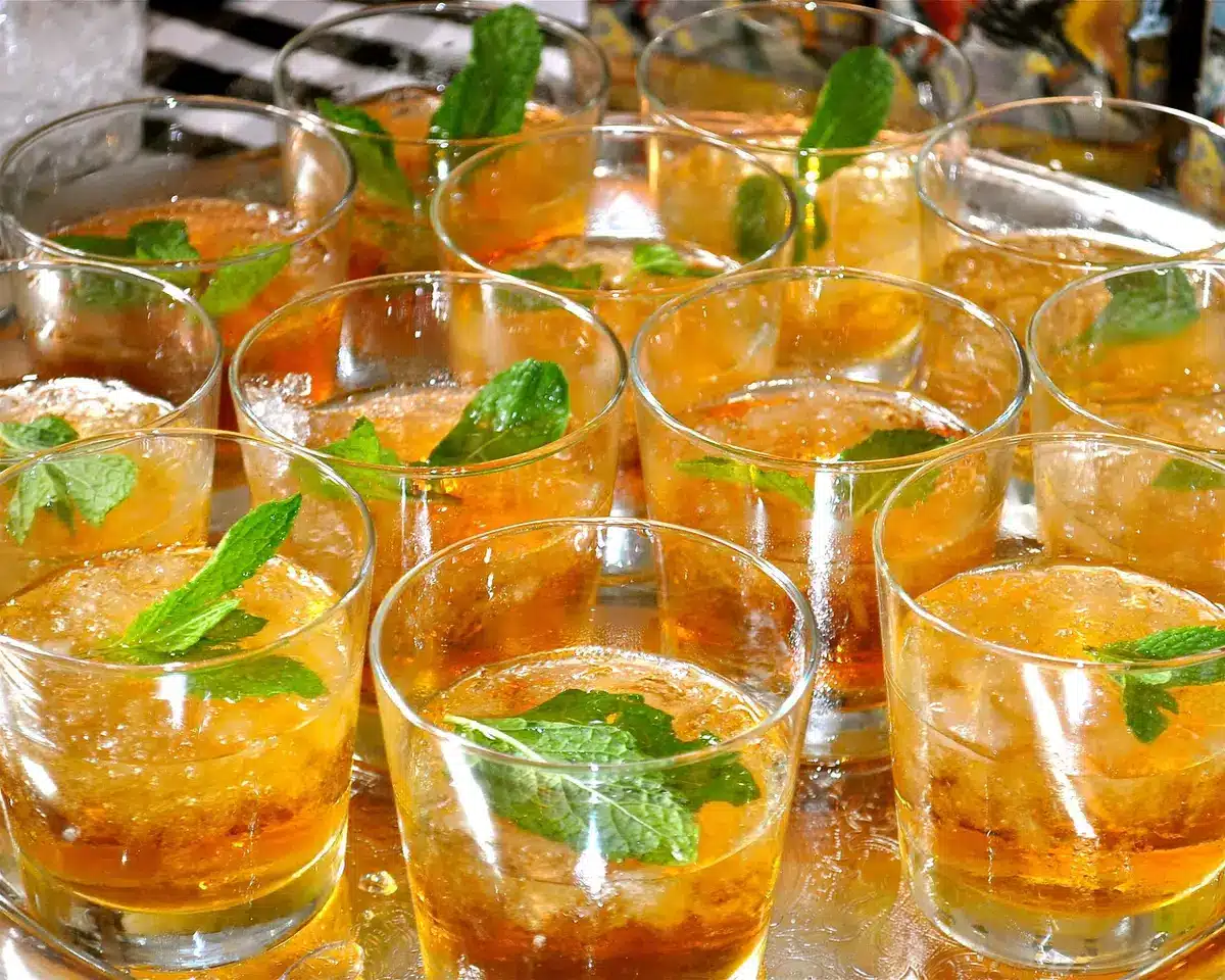 Bourbon tasting flight with several small pour glasses on a wooden board