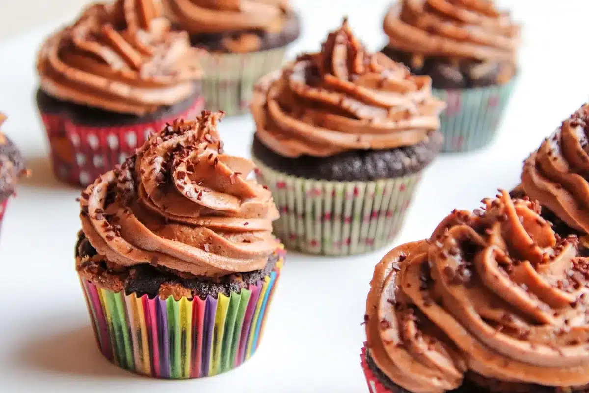 Close-up of a mixing bowl with cocoa powder and whisk near an oven