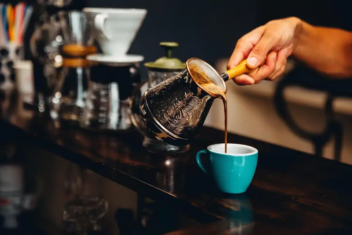 Barista handing a to-go coffee cup across a counter