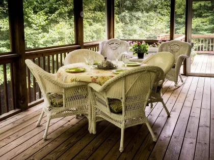 Elegant outdoor restaurant patio with diners at tables under soft evening light, overlooking coastal landscape