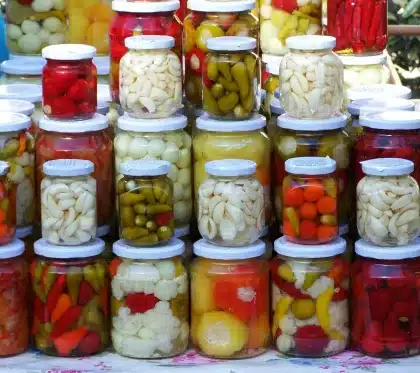 Server placing a small condiment tub and pickles on a fast-food counter