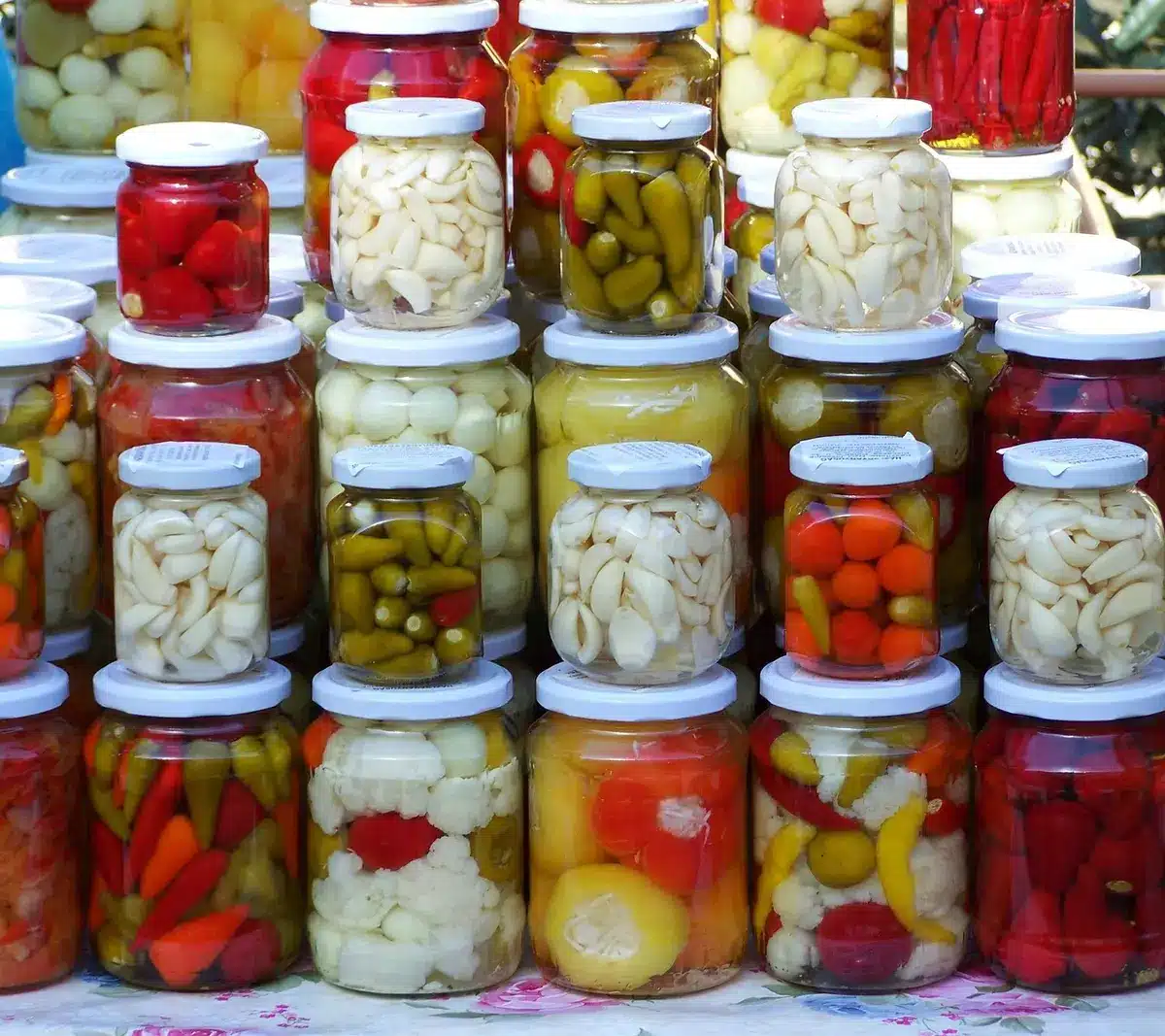 Server placing a small condiment tub and pickles on a fast-food counter