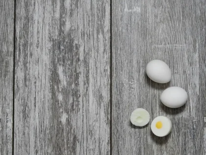 Two cooked fast-food eggs on a metal service counter, one square and one round