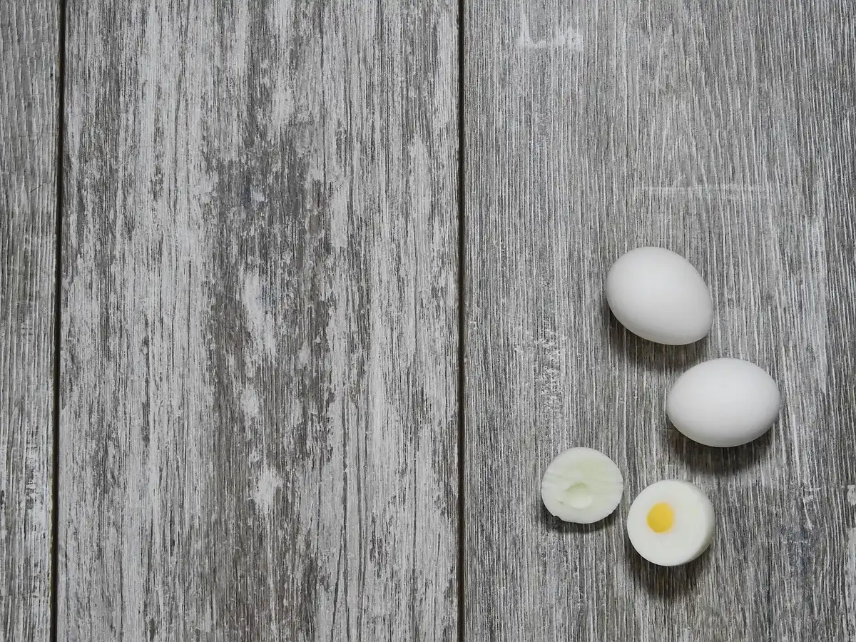 Two cooked fast-food eggs on a metal service counter, one square and one round