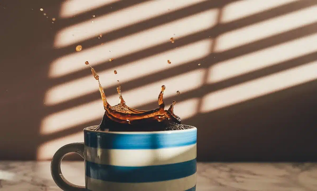 Close-up of a coffee cup and scattered tiny particles representing microplastics