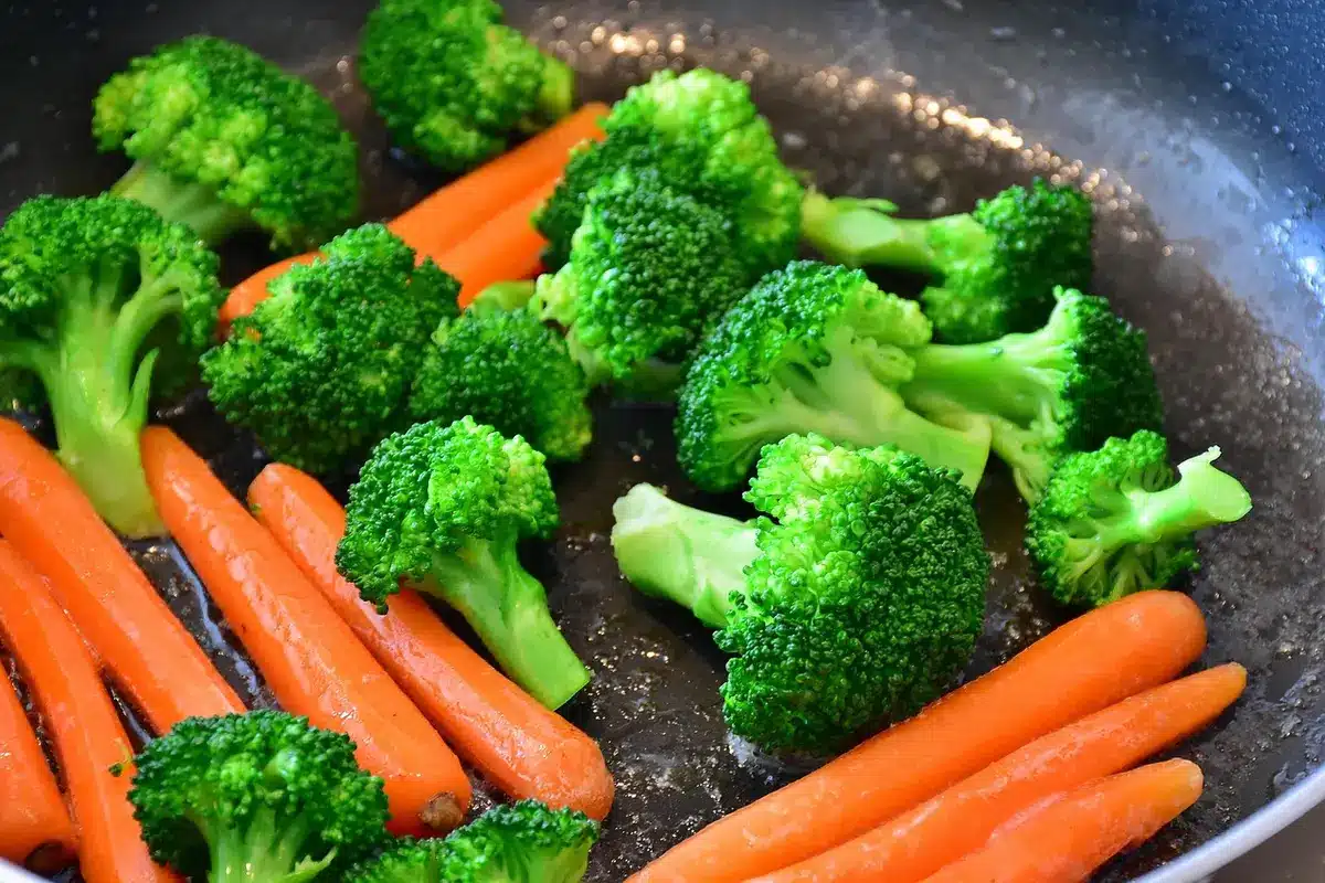 Vegetables arranged single layer on a rimmed sheet pan ready to roast