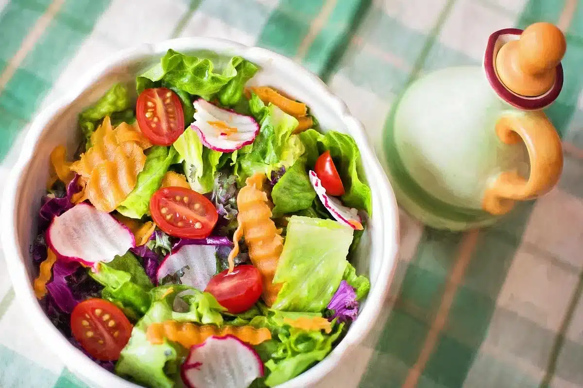 Bowl of briny clam soup beside a lemon-dressed green salad