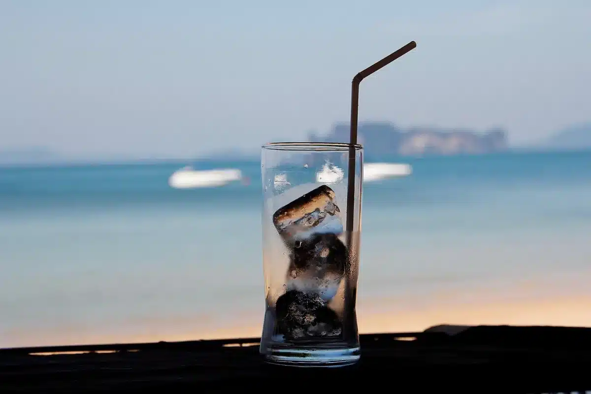 Glass of single malt whisky mixed with cola and ice on a bar counter