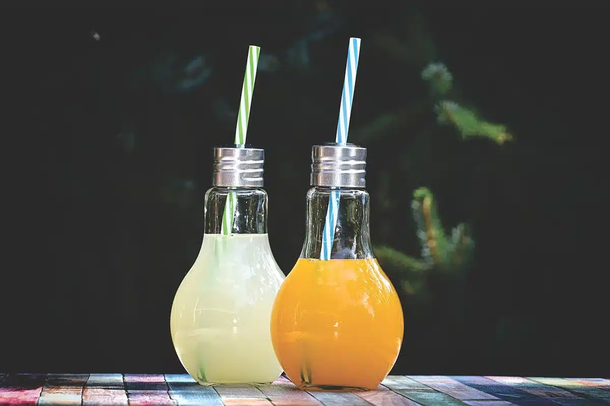 Glass of pink lemonade with ice and lemon wedge
