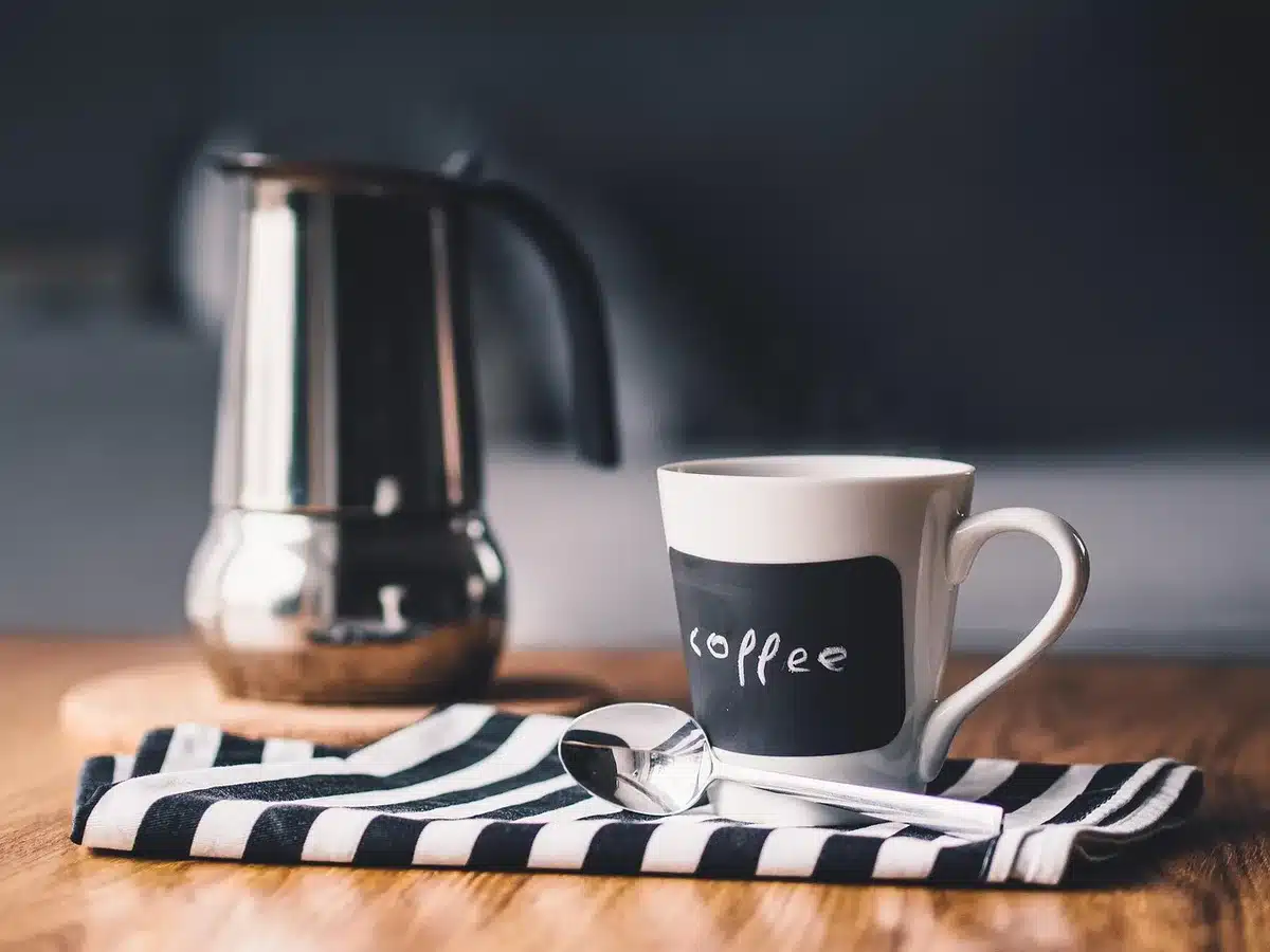 Close-up of coffee grounds, a kettle and a thermometer illustrating grind and temperature control