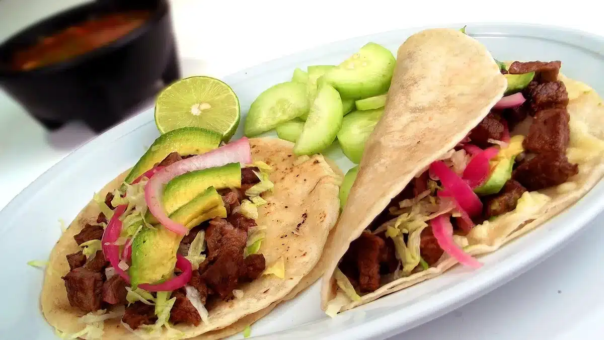 Tacos de carne asada y cochinita pibil servidos en un taquer&iacute;a tradicional