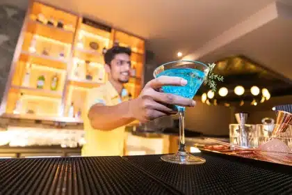 Busy restaurant bar with anonymous bartenders and a tray of mixed drinks