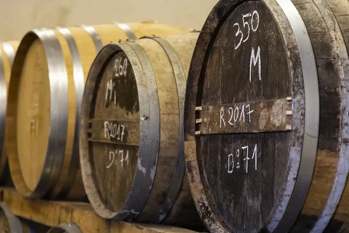Stacked oak barrels in a distillery racking room