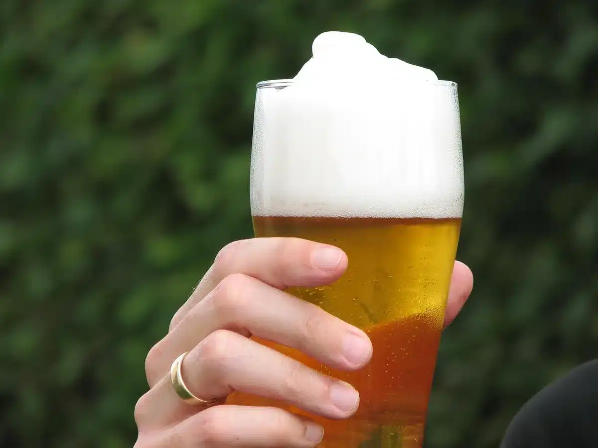 Hand sprinkling salt into a beer glass with lime on a kitchen counter
