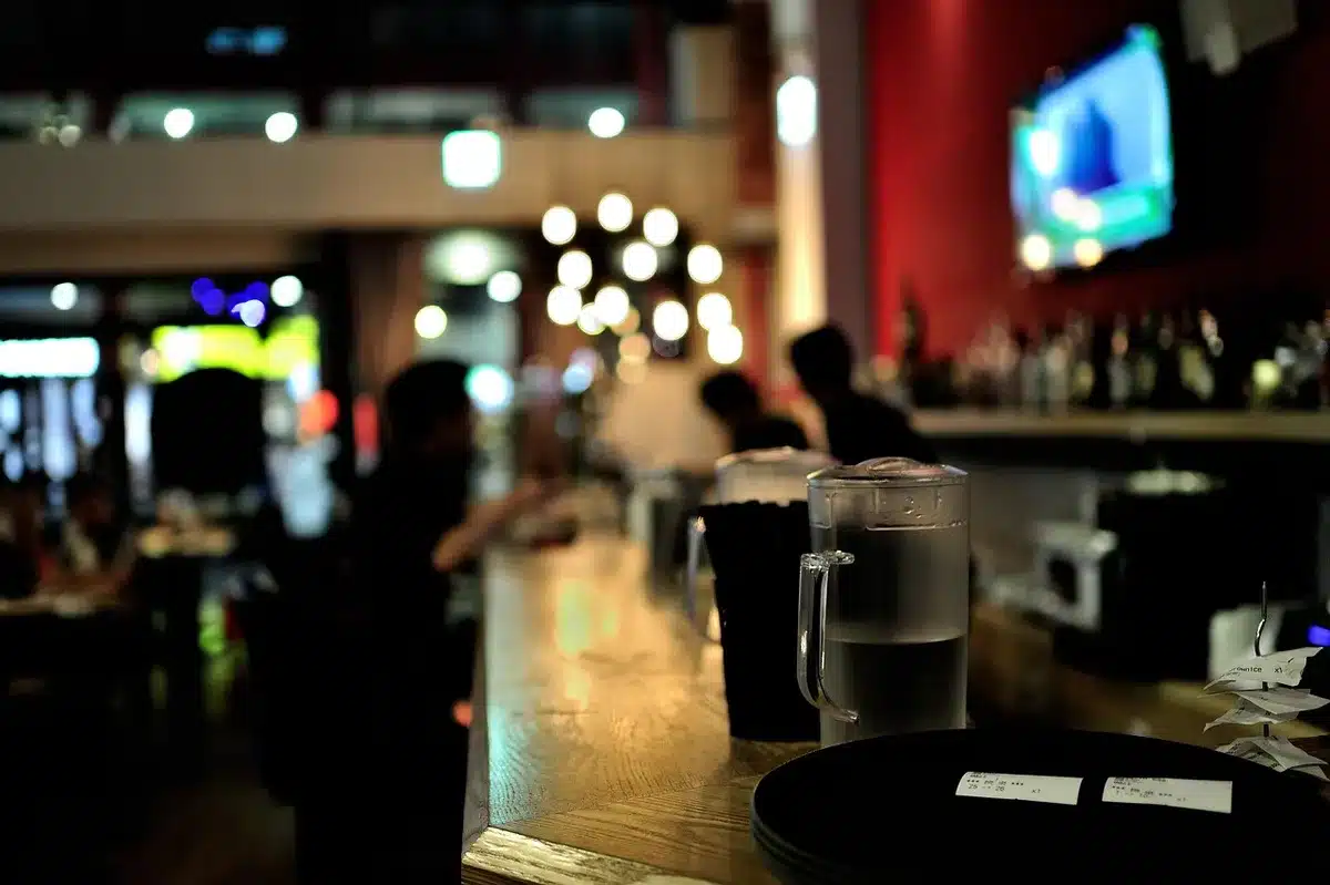 Interior lounge with multiple TV screens showing a game and guests seated