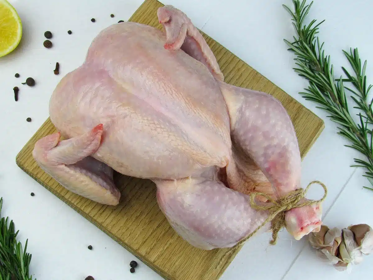Half roasted chicken with lemon and thyme on a plate with roast potatoes