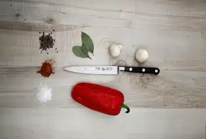 Overhead of a whole fish on a cutting board with a fillet knife and tools on a kitchen counter