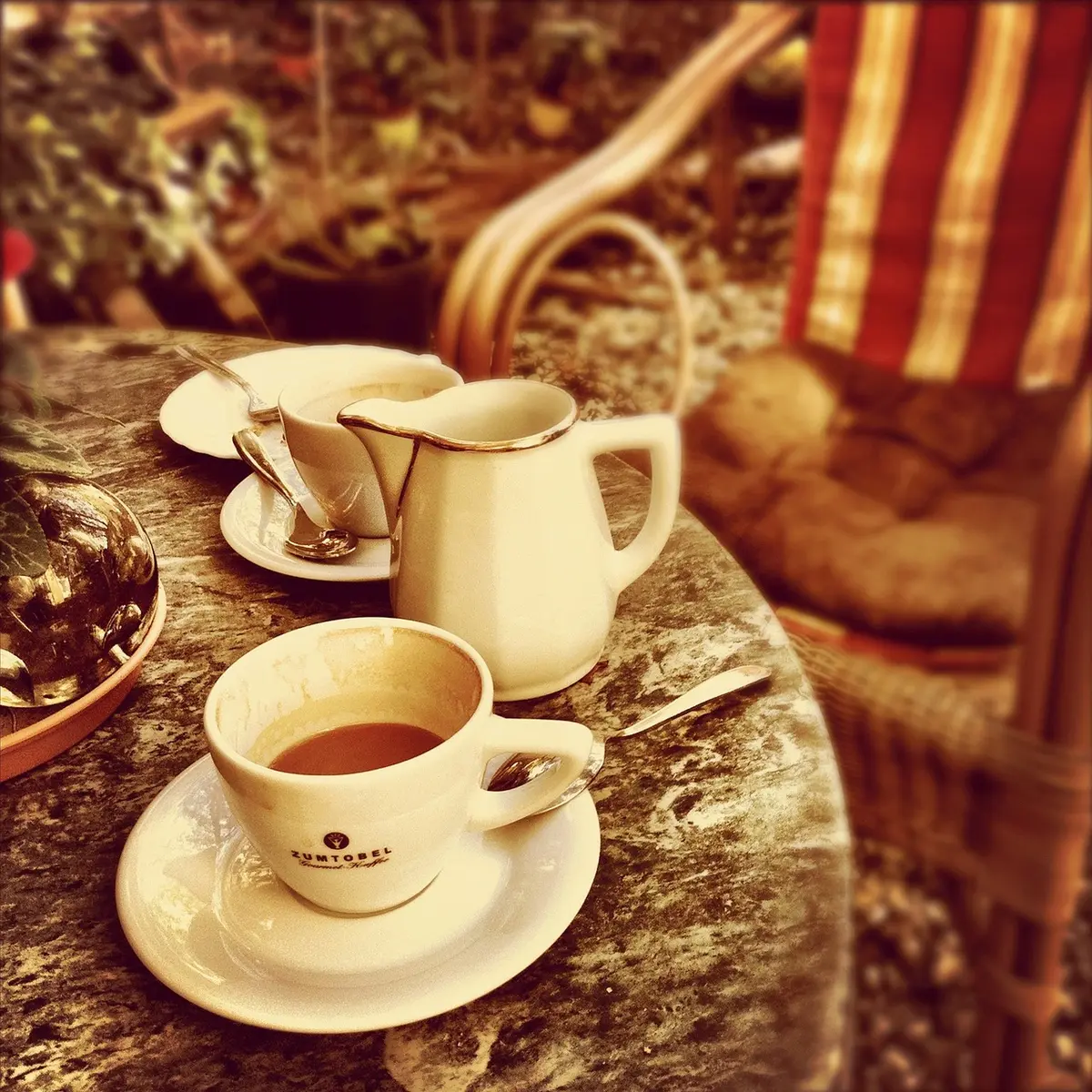 Tasting spoon beside a cup of coffee being tested for creamer flavor